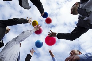 Low angle view of businesspeople throwing balls